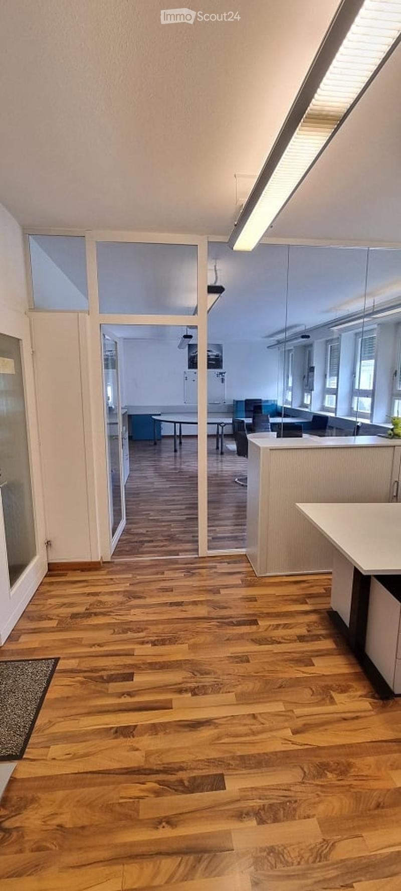 modern office with wood flooring, white walls, glass doors, glass windows, tables, chairs, reception desk, modern lighting