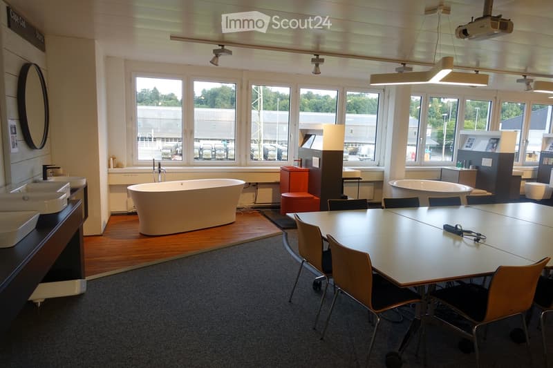 Interior with desks and chairs, bathtubs, sinks, mirrors, windows, and projector