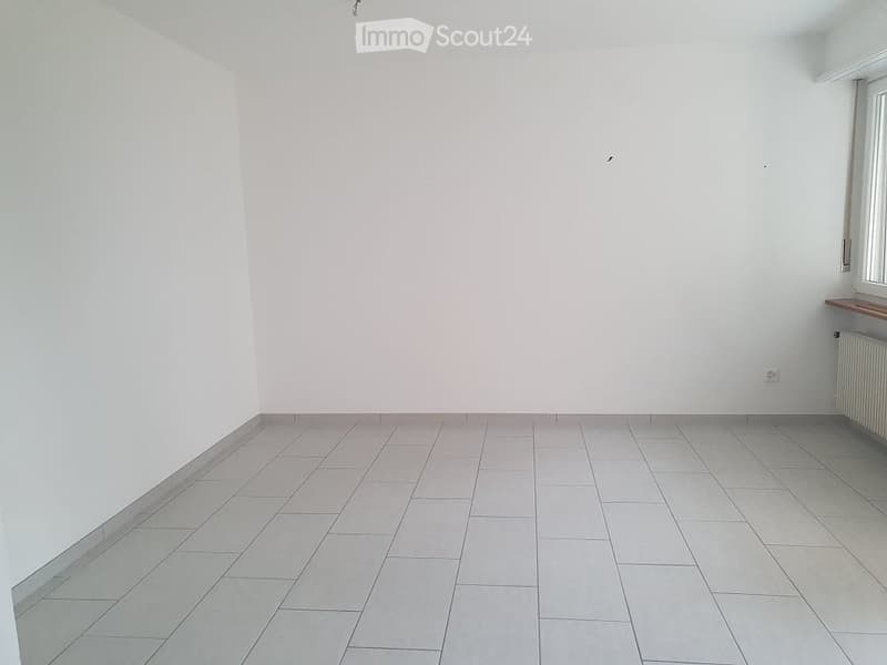 empty room with white tiles and white walls