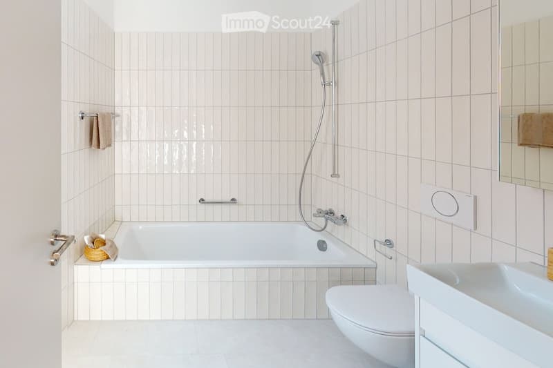 white tiles, bathtub, shower head, towel hanging, sink, toilet