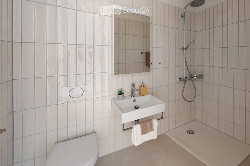 white tiles, white toilet, white sink, shower head, mirror