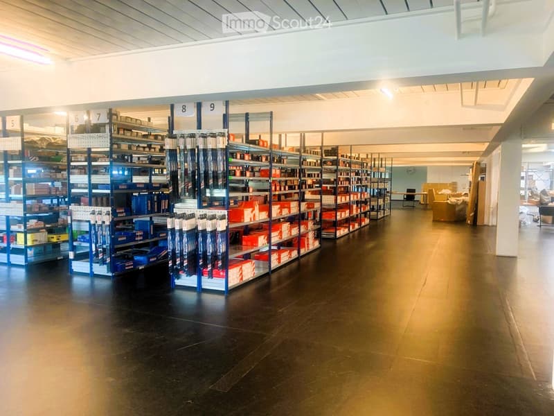 Large warehouse with metal shelving, numbered sections, stocked with boxes, yellow and blue bins, and various products.