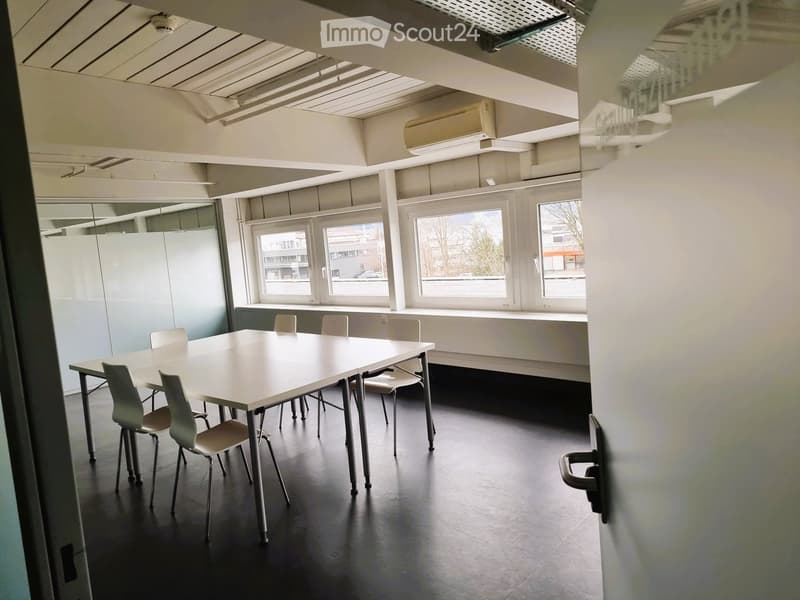 Table, chairs, windows with view, white walls, black flooring