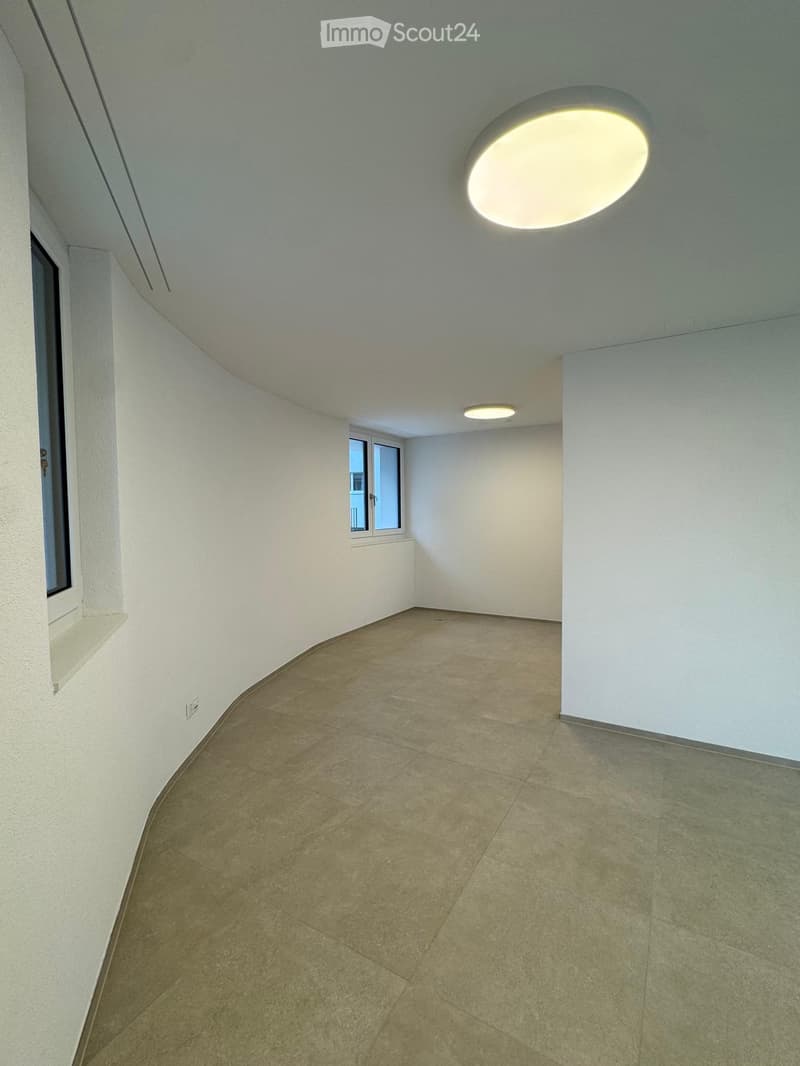 curved room, white walls, tiled floor, two windows, built-in lights