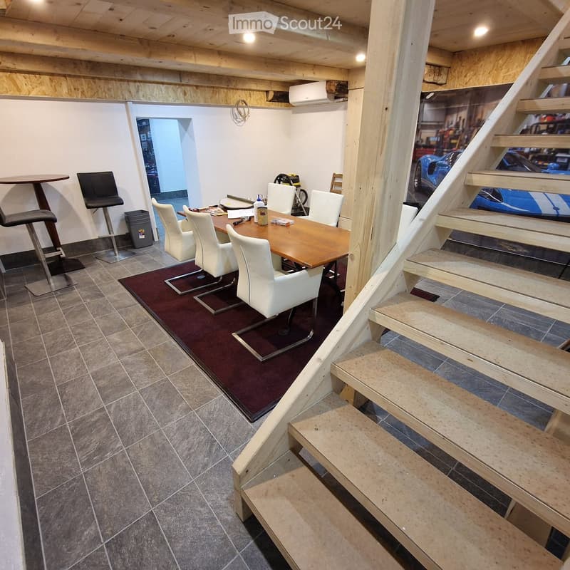 Dining room, raised ground floor, wooden table, white chairs, wooden stairs, red carpet