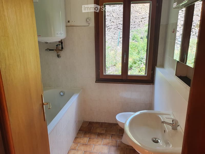 Bathroom: bathtub, sink, toilet, radiator, windows, tiled floor, tiles on the wall