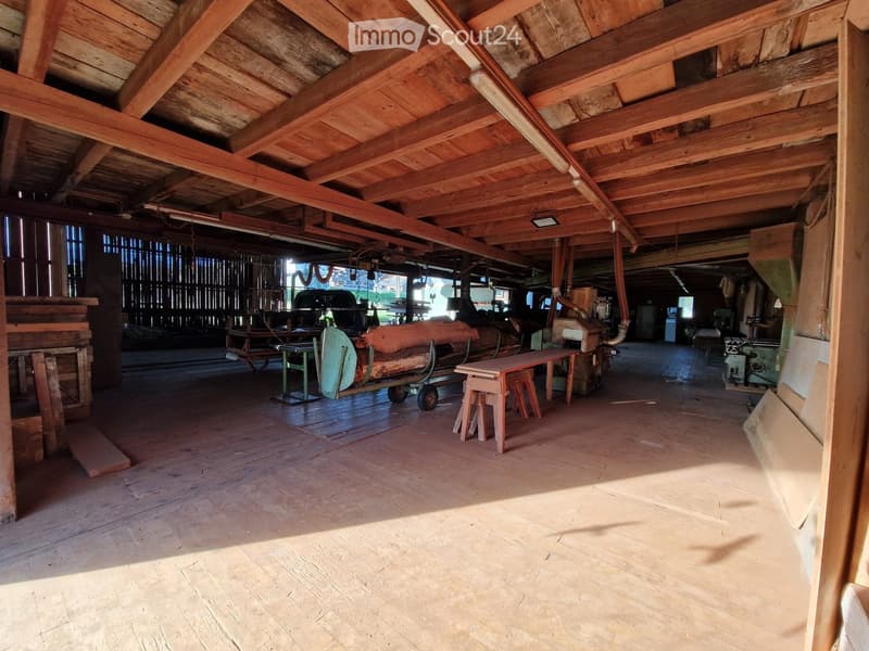 spacious workshop, wooden floor, metal workbenches, woodworking machinery, sunlight