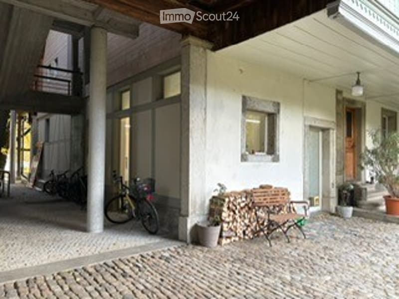 cobblestone street, building with wooden ceiling, bicycle parked, wooden bench, firewood, lamp