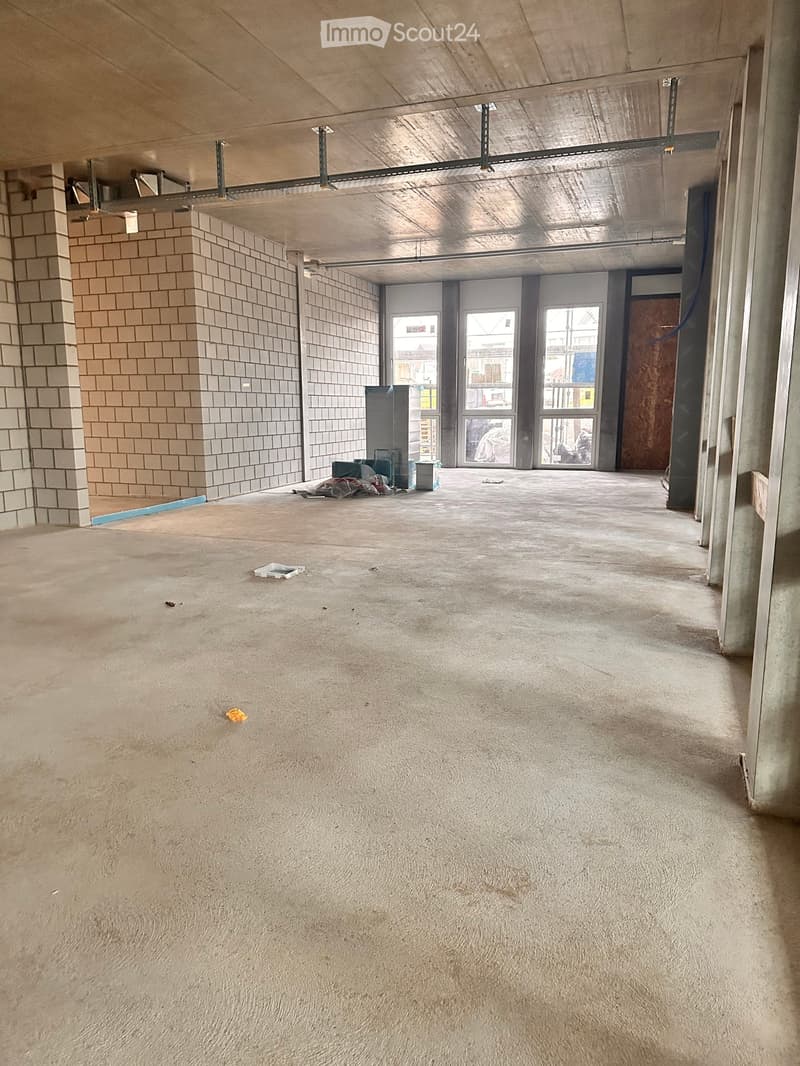 A room with white tiled walls, empty room, large windows, and white floor