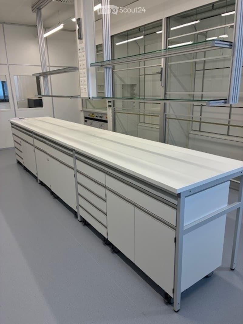 A white industrial workspace with multiple cabinets and a large countertop.