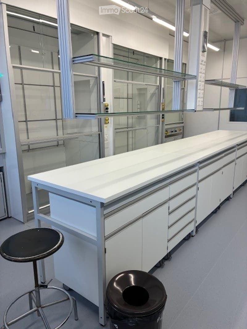 White countertops, stainless steel shelves, glass partitions, modern lab-like appearance, clean and organized