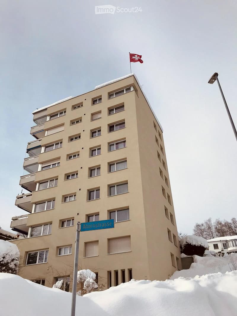 multi-story residential building with balconies, located in a snowy area