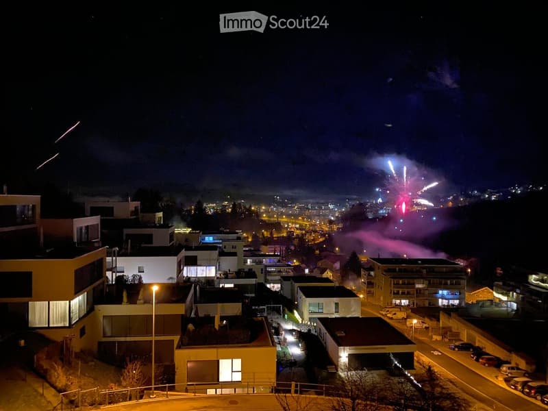 residential buildings, fireworks in the sky, night, streetlights, parked cars