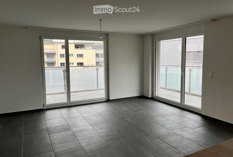 empty room, large sliding doors leading to a balcony, tile flooring, power outlet