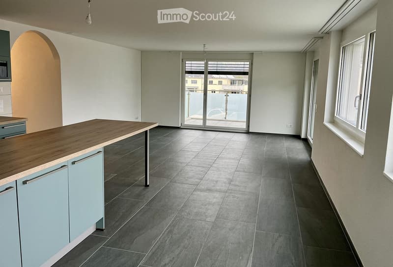 empty room, modern kitchen setup, large windows, glass doors leading to balcony, black tile flooring