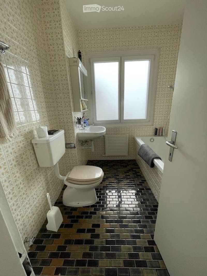 Bathroom with toilet, sink, bathtub, tiled floor, window