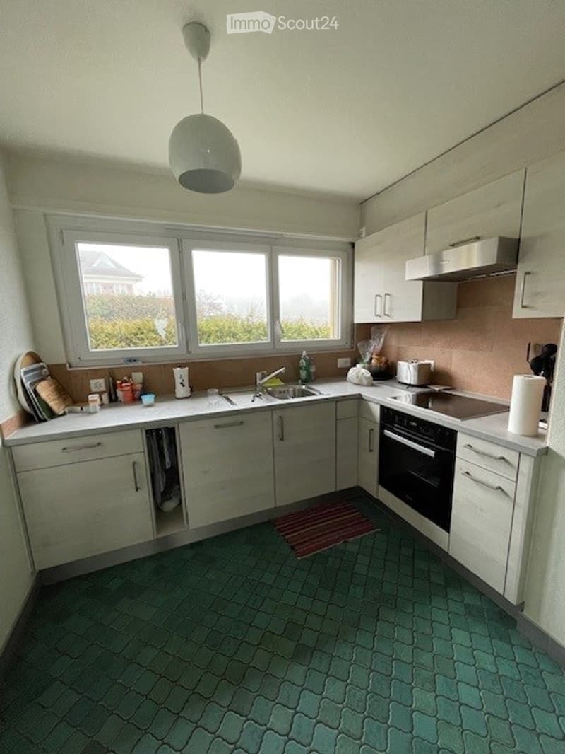 white cabinets, green tiled floor, stainless steel sink, countertop, large windows, kitchen appliances, kitchen utensils