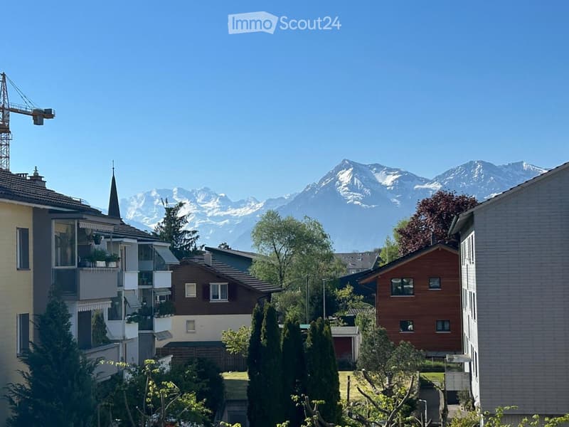 Mountain view, multiple houses, trees, clear sky