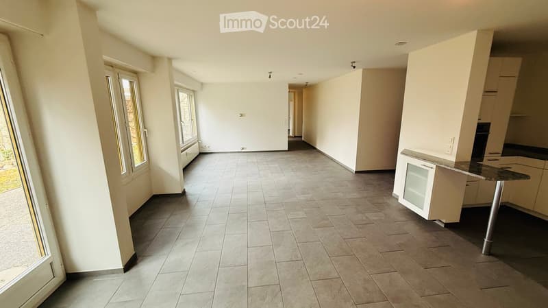 open room with white walls, tiled floor, windows, cabinets, glass door