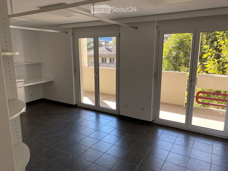 Open room with sliding doors to balcony, tiled flooring, white walls, three built-in cabinets