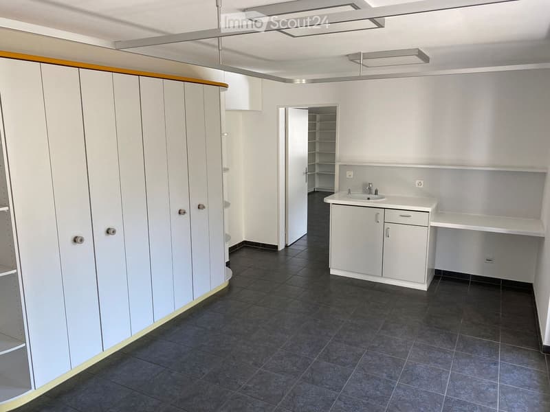 Empty room with white cupboards, tiled floor, sink with faucet, large wardrobe, white walls, power outlets.