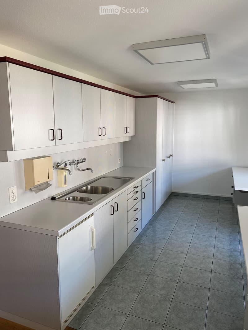 empty kitchen with grey tiled floor, sink, drawers, cabinets