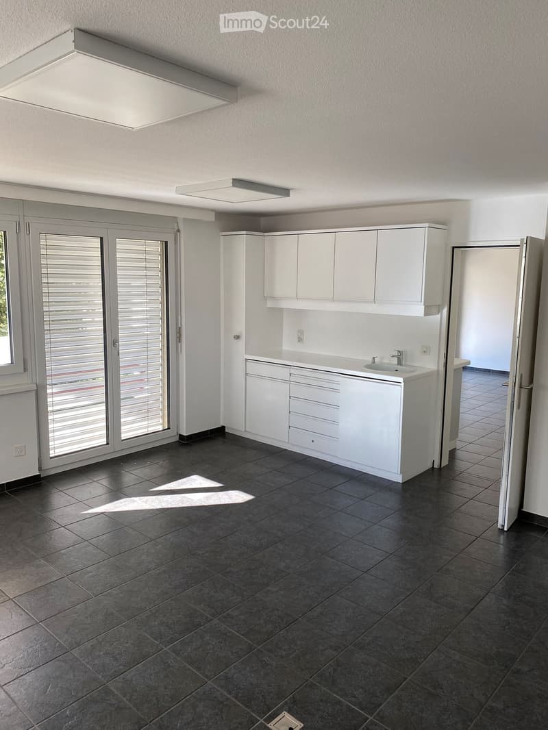 white cabinets, tiled floor, large sliding glass doors, two wall lights, single sink
