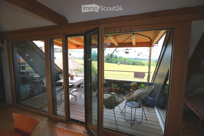 wooden floor, balcony with furniture, wide windows with views of the countryside, wooden frame