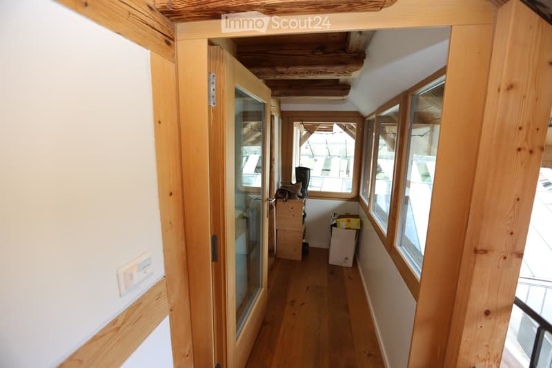 wooden floor, wooden frame, open doorway, large windows, view of outside