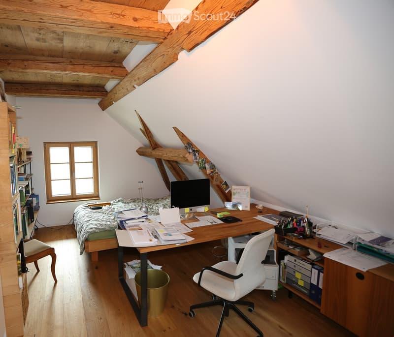 attic bedroom with desk, chair, bed, bookshelf, wooden floor, slanted ceiling