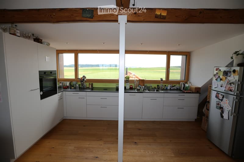 white cabinetry, wooden floor, large windows, integrated appliances