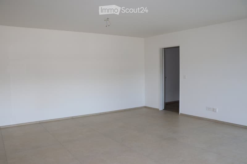 empty room with white walls, tiled floor, power outlets, door