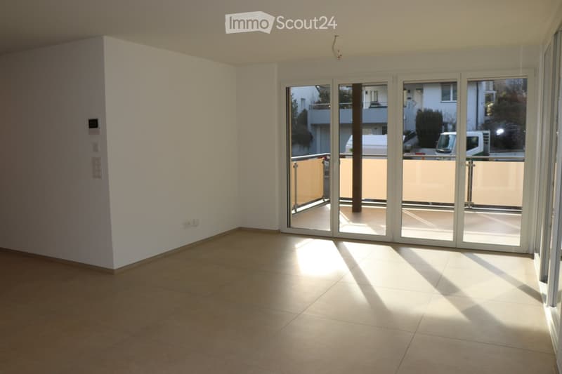 empty room, large glass sliding doors leading to balcony, tile floor, white walls, power outlets