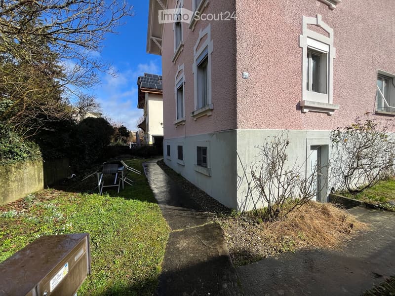 Building exterior, small pathway, sunny, green grass, no furniture, solar panels