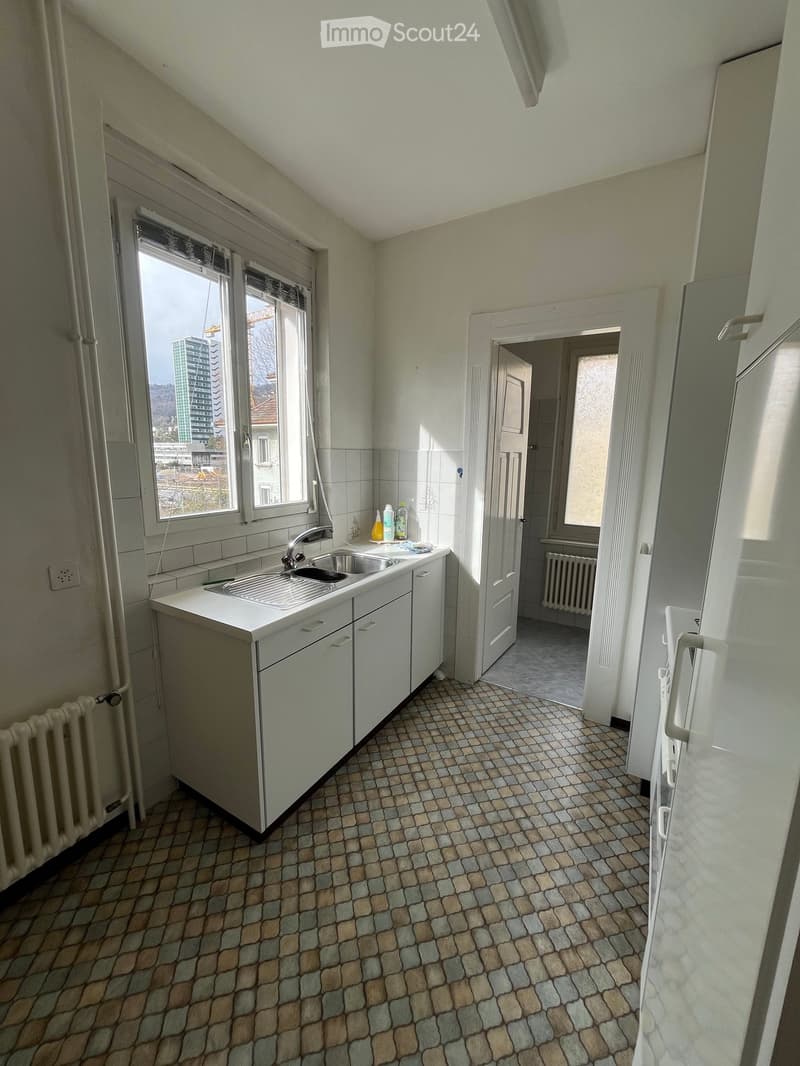 kitchen, counter, sink, faucet, cabinets, radiator, tiled floor, window, buildings in distance