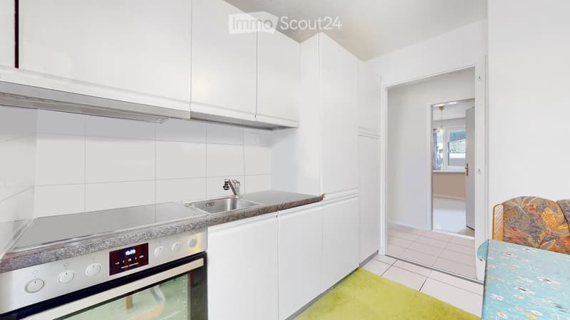 modern kitchen with a stove, sink, white cabinets, tiled floor