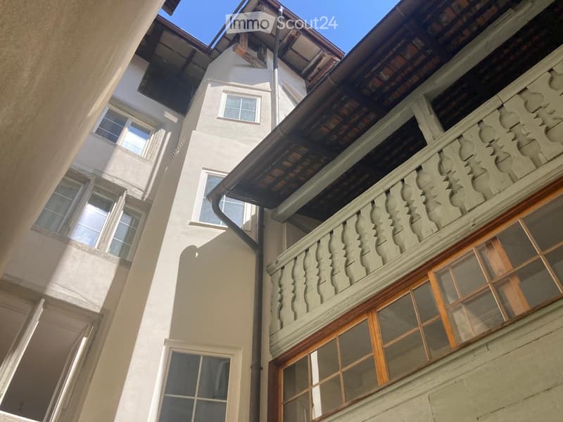 multi-story building, concrete construction, many windows, balcony with decorative railings