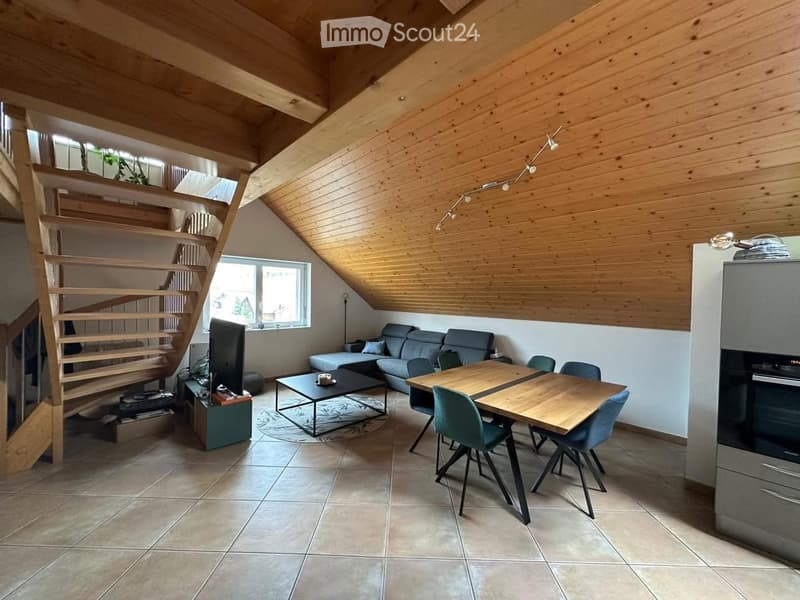 attic room with sloping ceiling, wooden floors, dining table, couch, tv stand, window