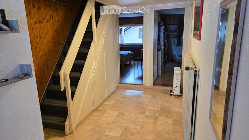 entrance hallway, wooden wall, tiled floor, stairs to the right leading to upper floor