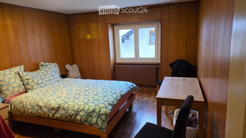 small double bed, wooden side tables, wooden floor, wardrobe, chair, window, radiator