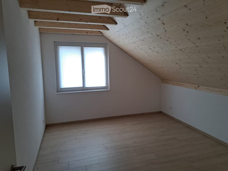 empty room with wooden floors, white walls, wooden ceiling, window