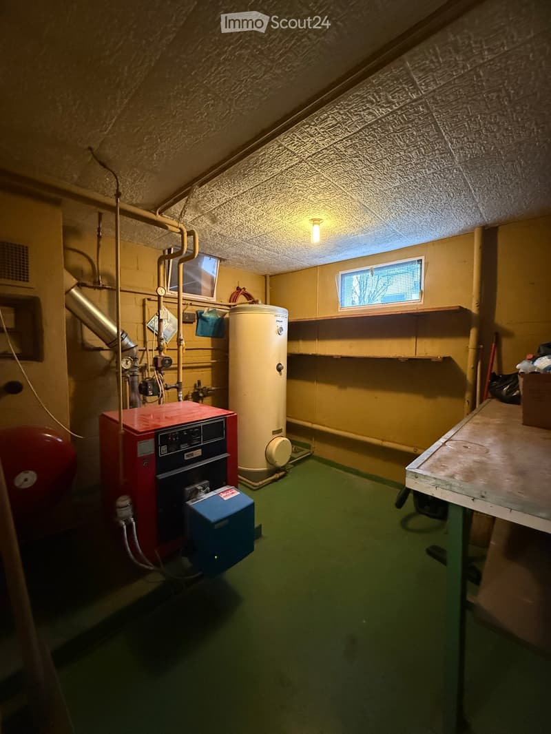 Basement with water heater, storage shelves, storage box, metal and wood table, ceiling fan