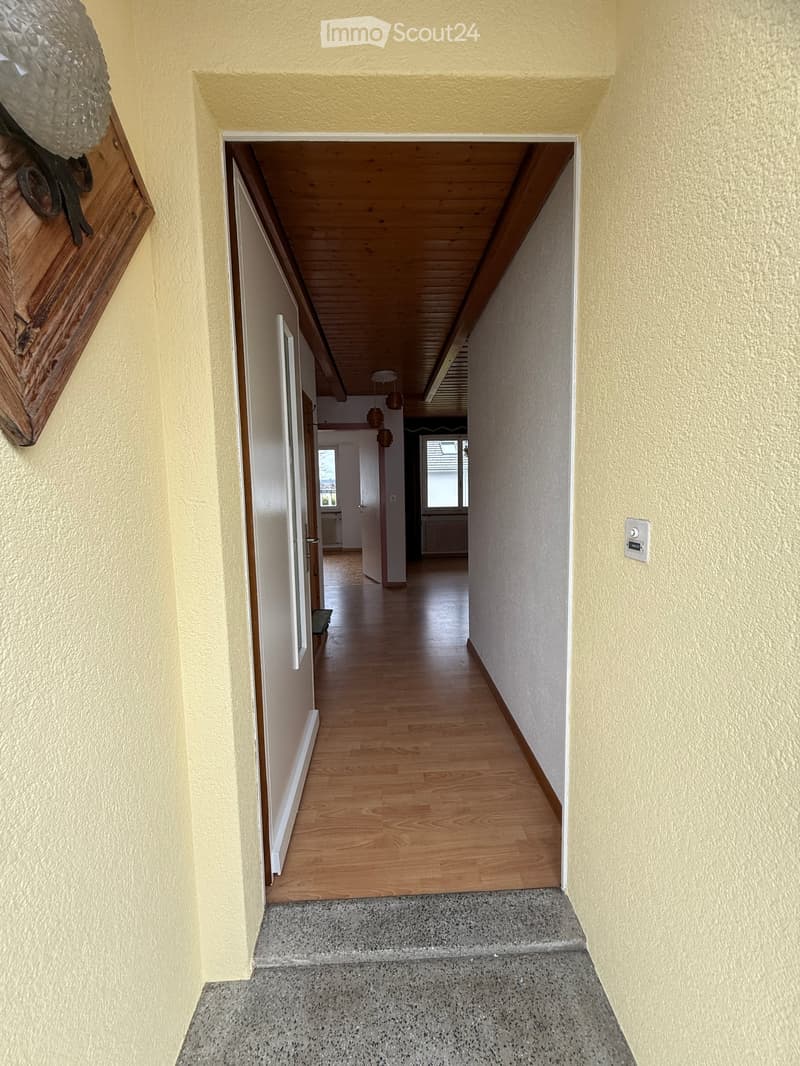 long corridor, yellow walls, wooden flooring, open door, interior light