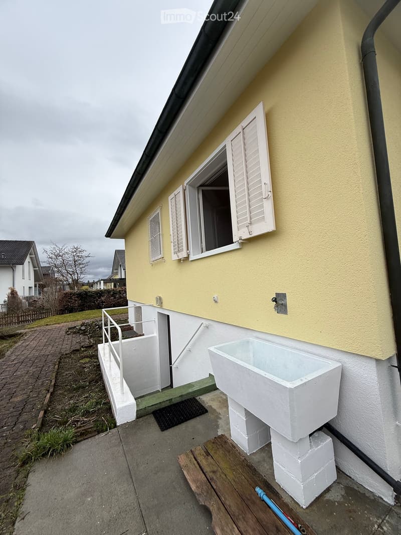 Yellow exterior, white shutters, raised ground floor, stone sink, metal handrail, drain