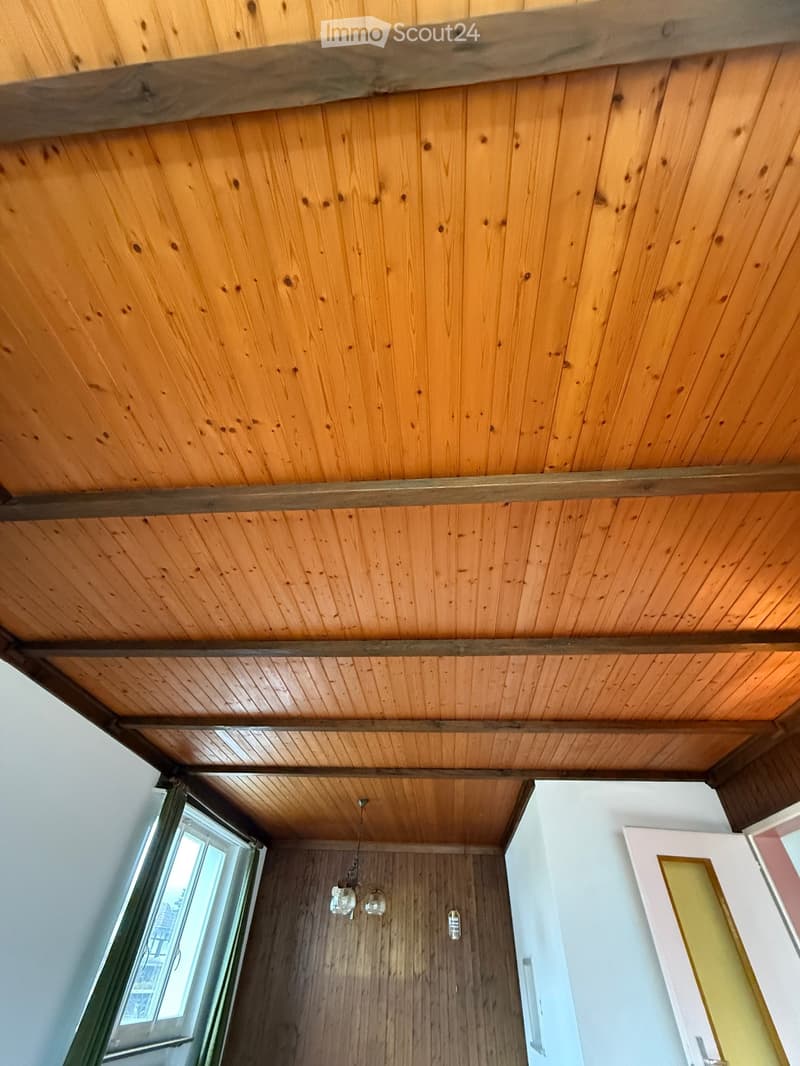 wooden ceiling, wooden walls, white walls, window, chandelier, white door