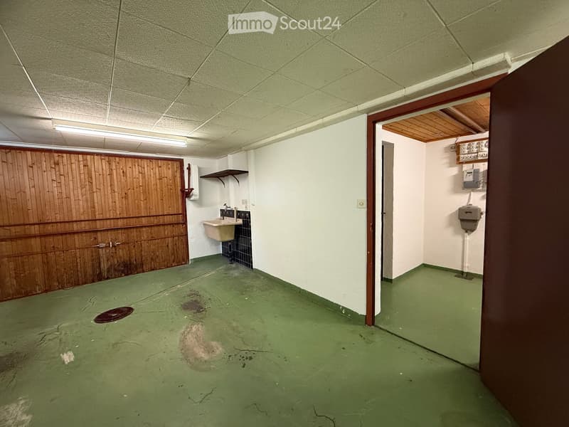 Bathroom with sink and urinal, wooden wall, tiled floor, electrical boxes