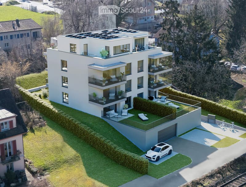 4 story modern residential building, solar panels on the roof, balcony on every floor, green lawn area, driveway with parking, 2 bicycles on the driveway