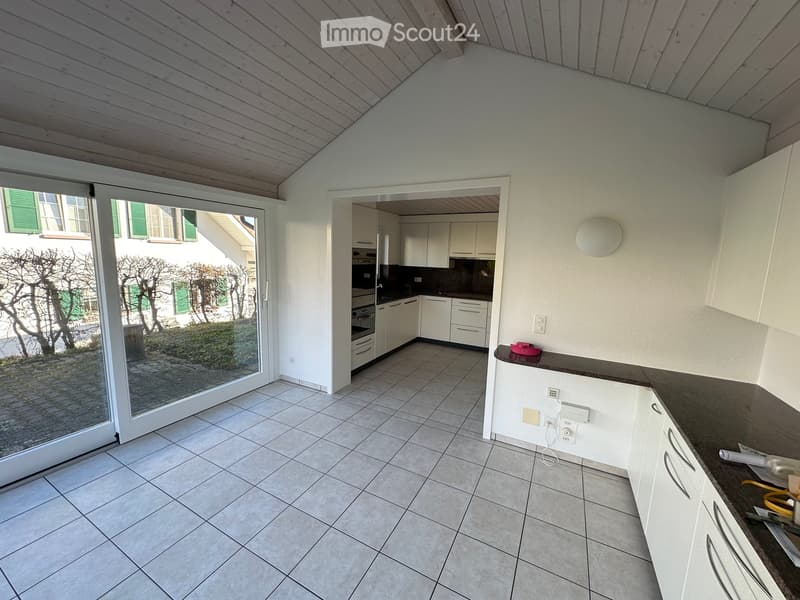 Open kitchen, tiled floor, kitchen appliances, sliding glass door, overhead lighting