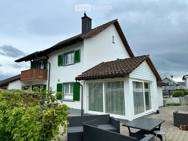 detached house, 2 stories, white exterior, brown roof, green shutters, balcony, large sliding doors, patio