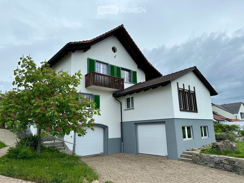2 story house, white exterior, green shutters, brown roof, 2 garages, driveway, tree, stairs, fenced yard